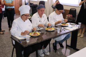 As juradas Rosi Siqueira, Ana Carolina Leão e Joyce Cafiero avaliam o prato de uma das equipes.
